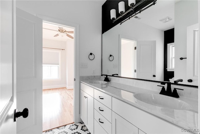 full bathroom featuring ceiling fan, wood finished floors, a sink, and double vanity