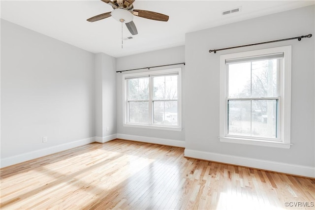 spare room with light wood finished floors, visible vents, baseboards, and a ceiling fan