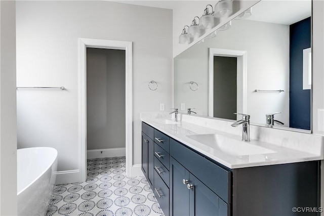 full bathroom featuring double vanity, a soaking tub, baseboards, and a sink