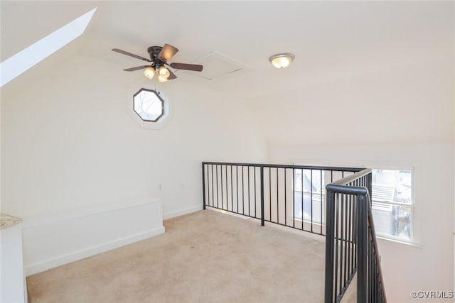 unfurnished room featuring a wealth of natural light, lofted ceiling, light colored carpet, and baseboards