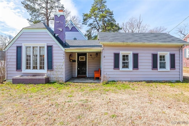 view of front of property featuring a chimney and a front yard