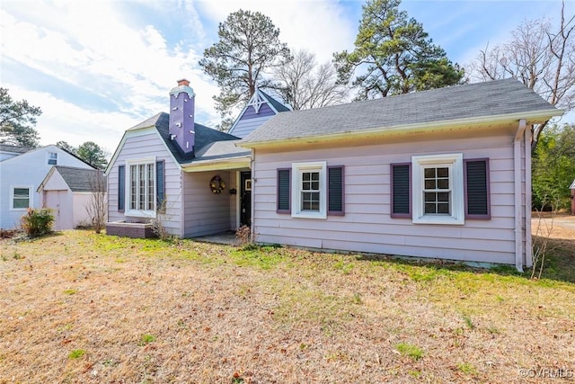 view of front of home featuring a chimney and a front yard