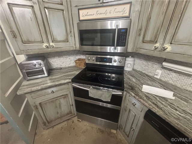 kitchen featuring dark stone countertops, decorative backsplash, and stainless steel appliances