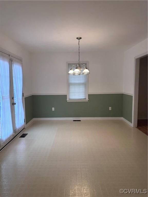 spare room featuring a chandelier