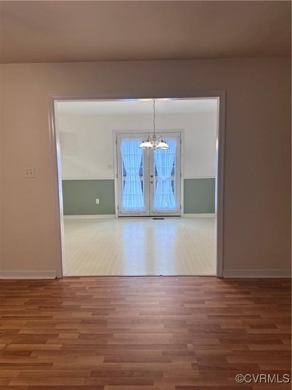 unfurnished dining area with an inviting chandelier and wood-type flooring