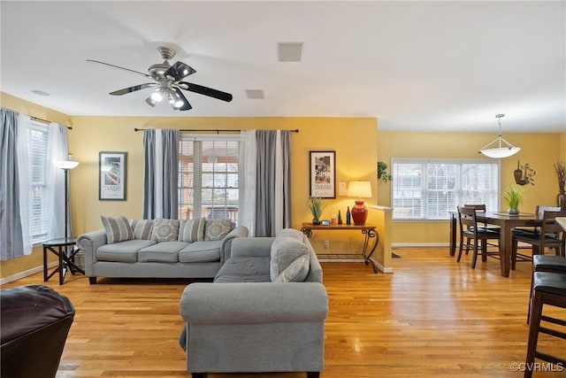 living room with light hardwood / wood-style flooring and ceiling fan