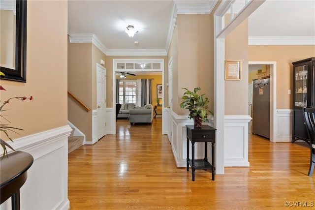 foyer entrance with light wood-type flooring and ornamental molding