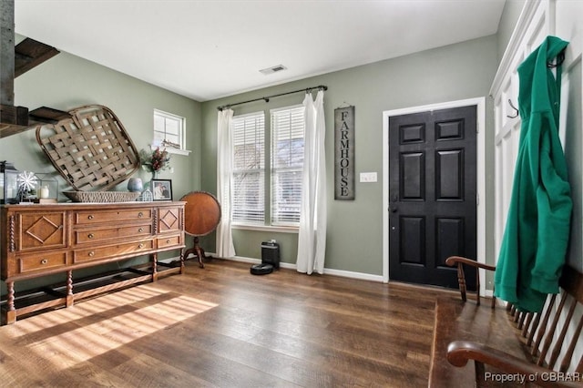 foyer with wood finished floors, visible vents, and baseboards