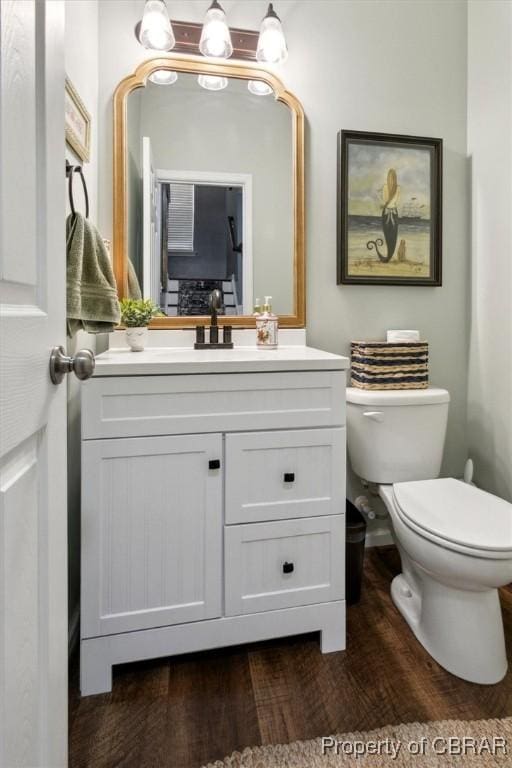 bathroom with vanity, toilet, and wood finished floors