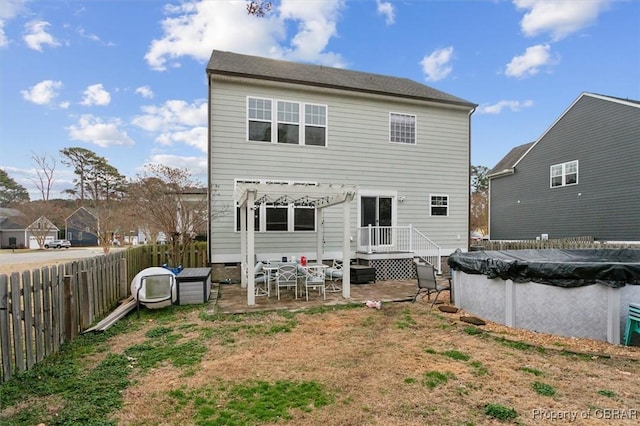 rear view of house with a patio area, fence private yard, and a fenced in pool