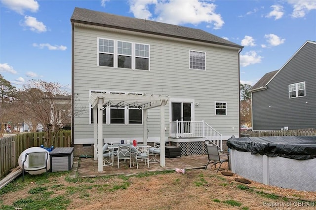 rear view of house with a patio area, fence, and a fenced in pool