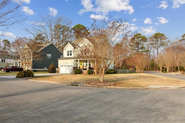 view of front of home with an attached garage, driveway, a front yard, and a residential view