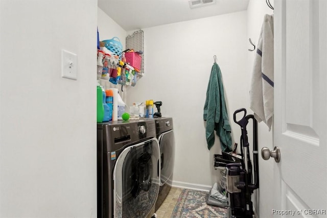 washroom featuring laundry area, washing machine and dryer, visible vents, and baseboards