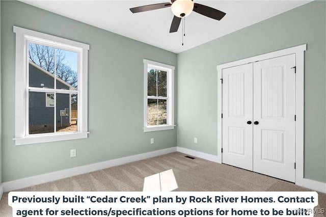 unfurnished bedroom featuring a closet, light colored carpet, visible vents, a ceiling fan, and baseboards