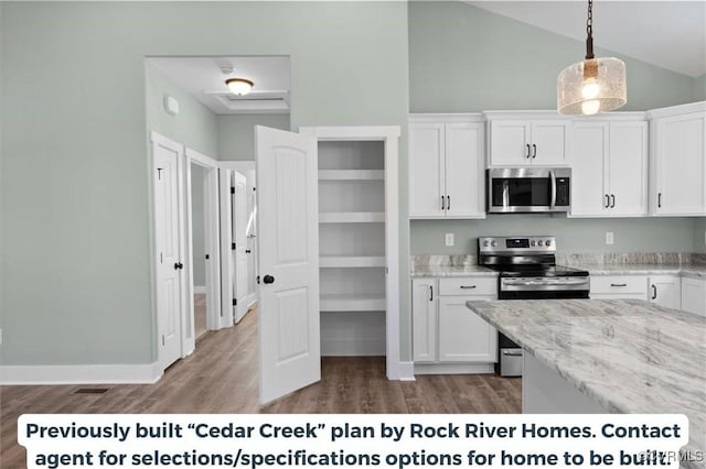 kitchen with light stone counters, wood finished floors, hanging light fixtures, stainless steel appliances, and white cabinetry