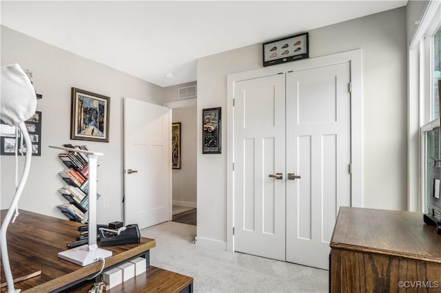 interior space featuring baseboards, visible vents, and light carpet