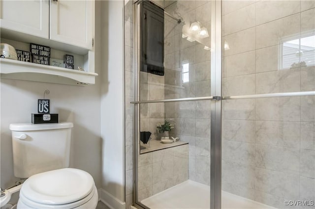full bathroom with toilet, baseboards, and a stall shower