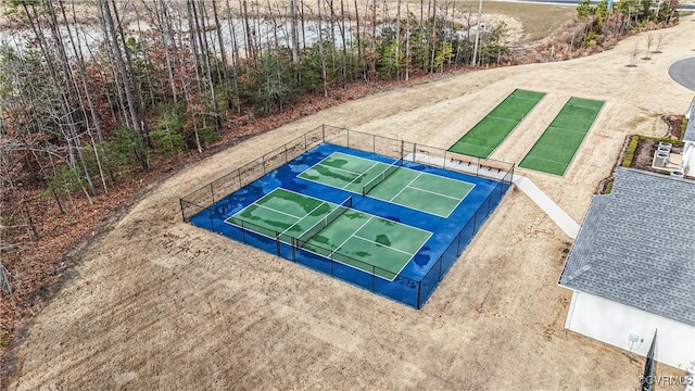 view of property's community featuring a tennis court and fence