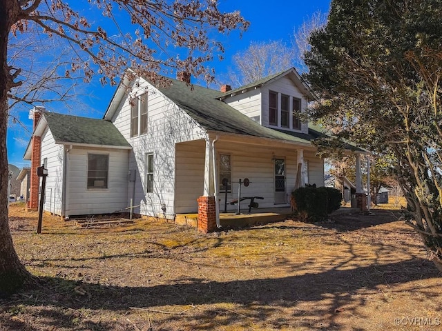 rear view of property featuring covered porch