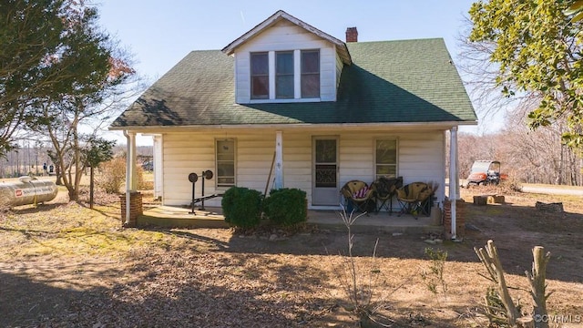 rear view of property featuring covered porch