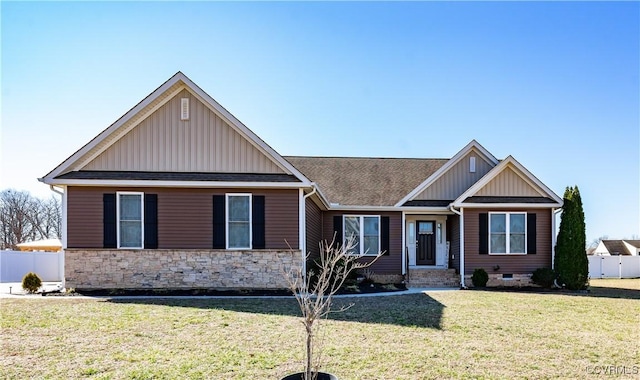 craftsman house featuring stone siding, fence, a front lawn, and board and batten siding