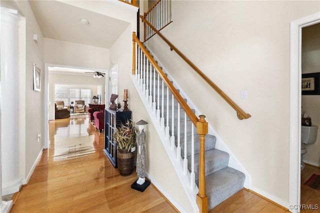 stairs with ceiling fan and wood-type flooring