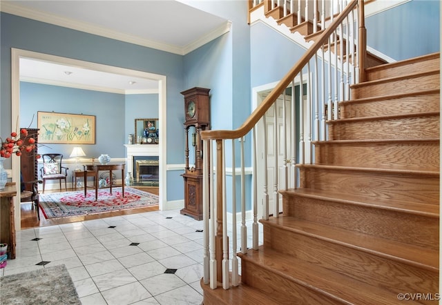 stairs featuring tile patterned flooring, a fireplace, baseboards, and crown molding