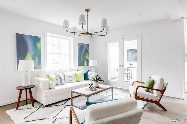 living room with light wood-type flooring, french doors, baseboards, and an inviting chandelier