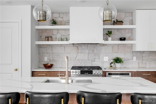 kitchen featuring stainless steel range with gas cooktop, open shelves, tasteful backsplash, wall oven, and light stone countertops