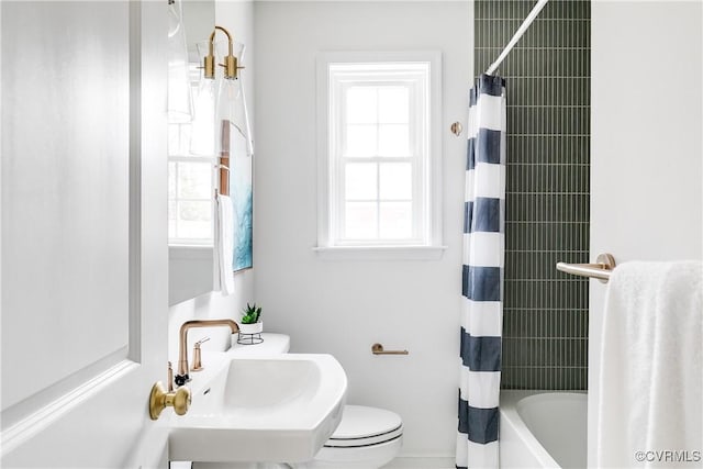 full bathroom with shower / bath combo with shower curtain, plenty of natural light, a sink, and toilet