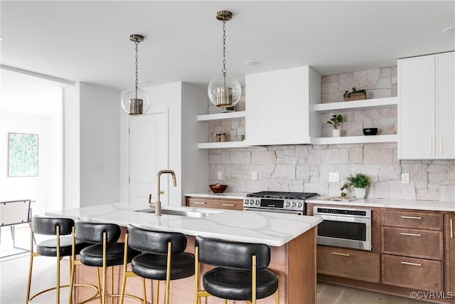 kitchen featuring stainless steel appliances, a sink, backsplash, and open shelves