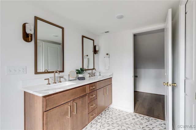 bathroom featuring double vanity, a sink, visible vents, and tile patterned floors