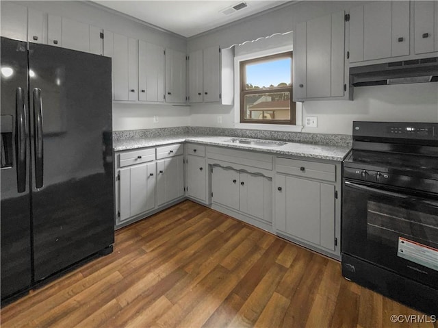 kitchen with hardwood / wood-style flooring, sink, and black appliances