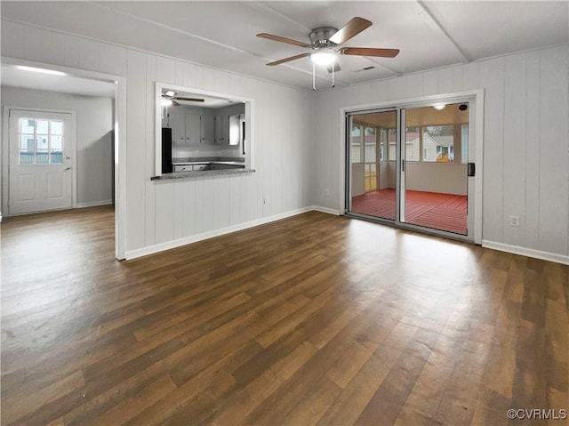 unfurnished living room with ceiling fan and dark hardwood / wood-style flooring