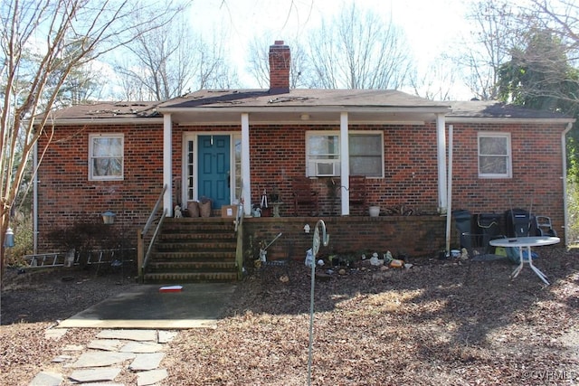 view of front facade with brick siding and a chimney