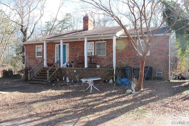 view of front facade with brick siding and a chimney