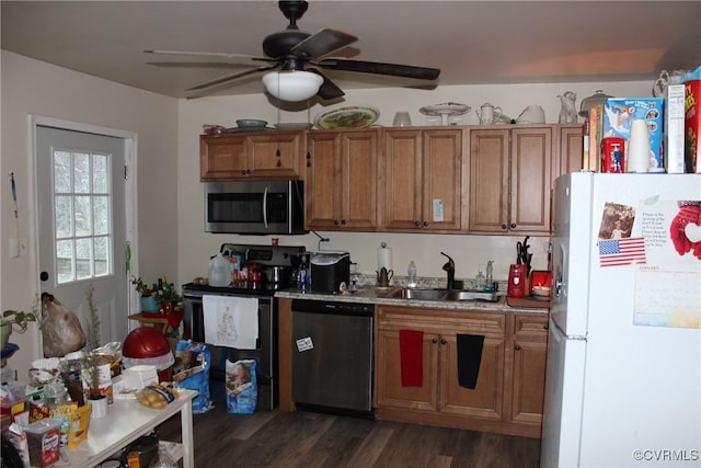 kitchen with brown cabinets, stainless steel appliances, dark wood-type flooring, a sink, and ceiling fan