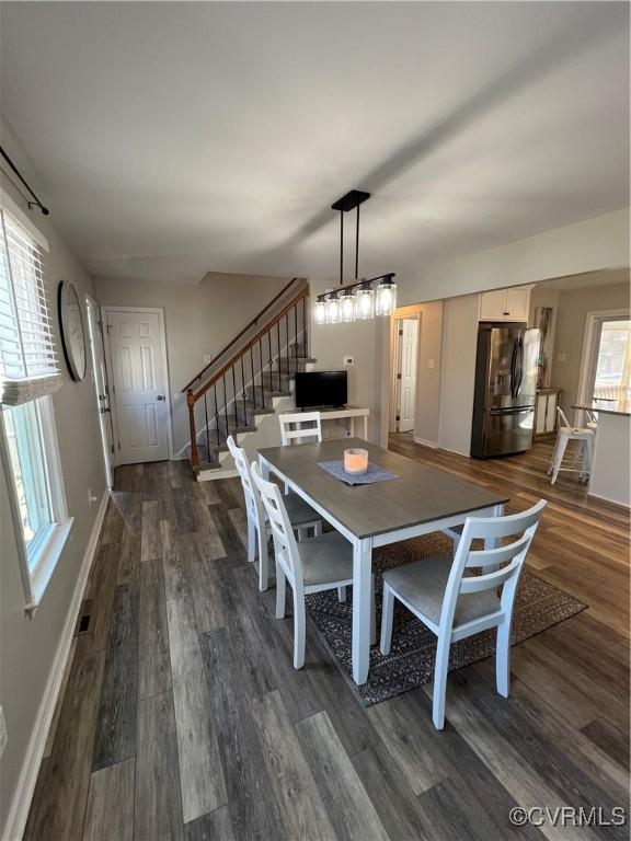 dining space with dark wood-style floors, stairs, and baseboards