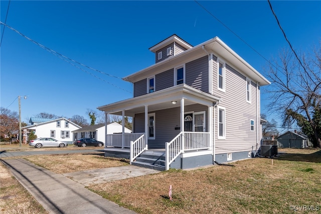 american foursquare style home with covered porch, central AC, and a front lawn