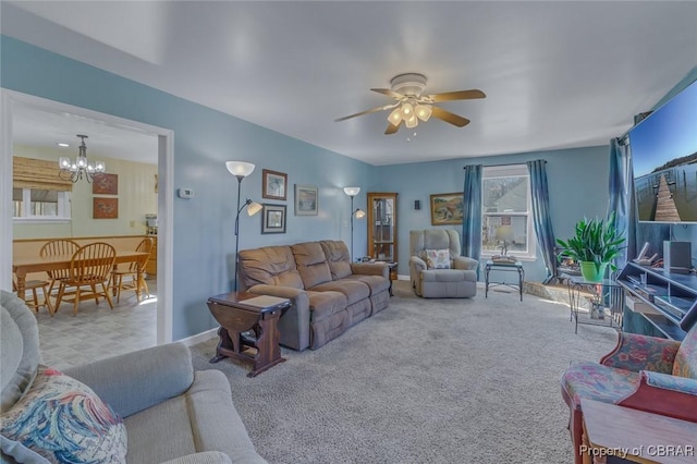 living room with ceiling fan with notable chandelier and carpet