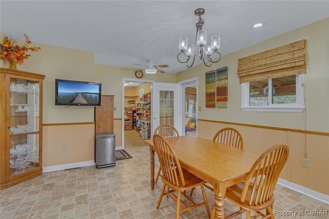 dining area featuring ceiling fan with notable chandelier