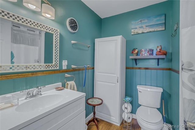 bathroom featuring wood-type flooring, toilet, a shower with shower curtain, and vanity