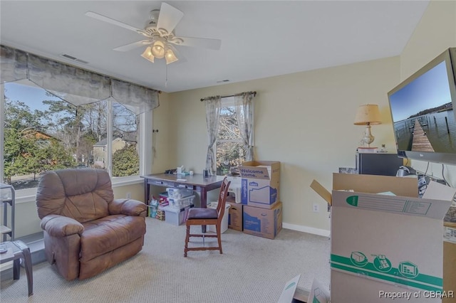 living area featuring ceiling fan and carpet