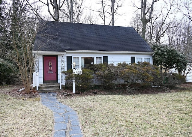 cape cod house featuring a shingled roof and a front yard