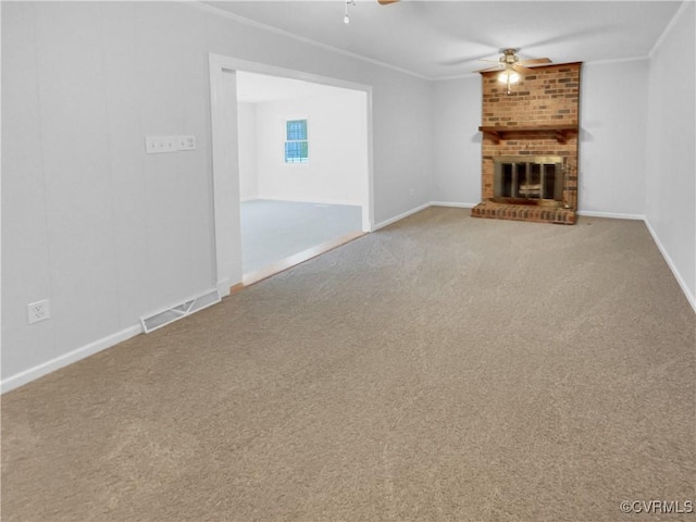 unfurnished living room with ornamental molding, ceiling fan, carpet floors, and a brick fireplace