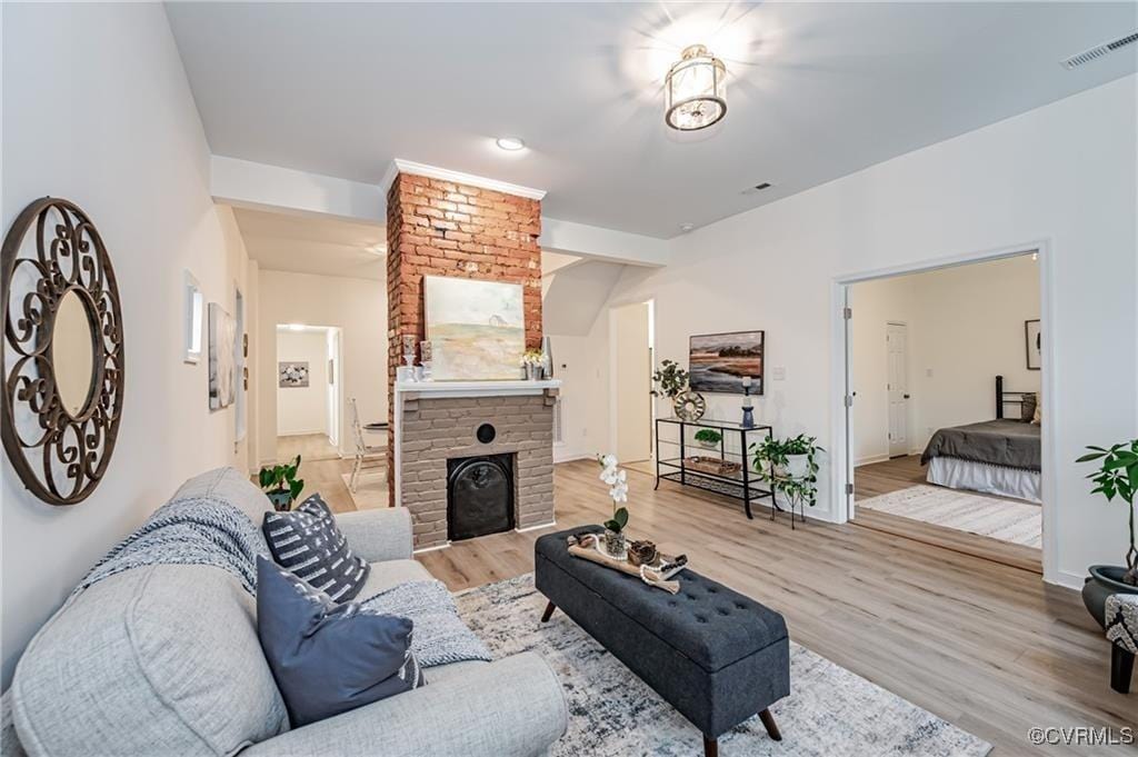 living room featuring a brick fireplace and hardwood / wood-style floors