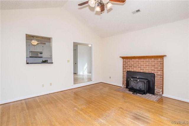 unfurnished living room with lofted ceiling, light wood-style floors, baseboards, and visible vents