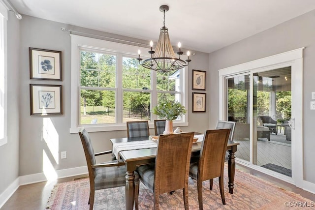 dining room with a chandelier and baseboards