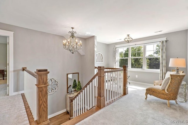 stairway featuring a chandelier, carpet flooring, and baseboards