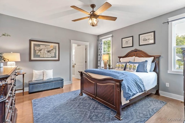 bedroom featuring a ceiling fan, baseboards, and wood finished floors